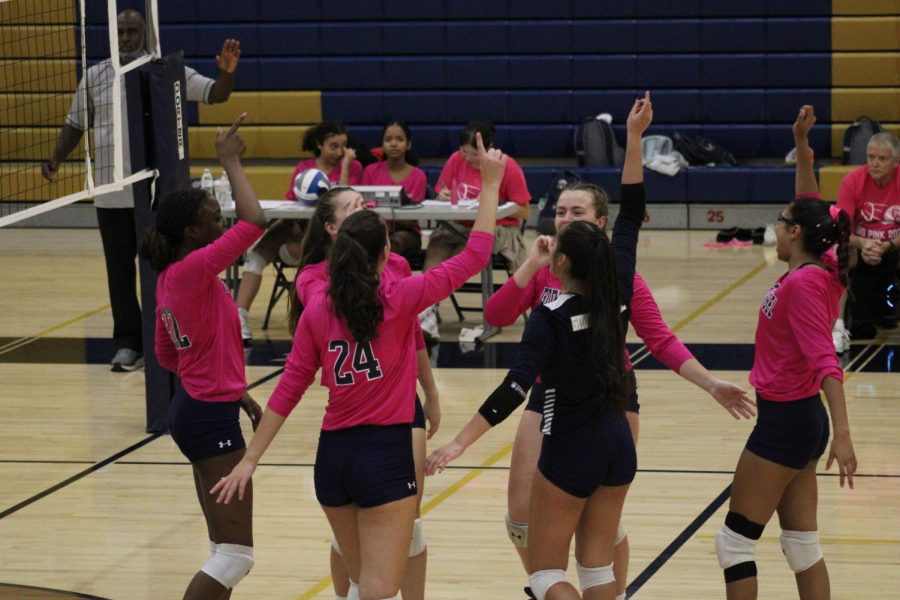 The volleyball team celebrates during their annual Dig Pink game.