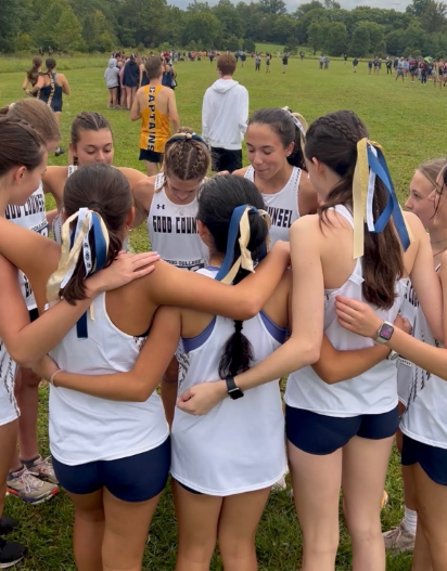 Ella Berge and the Cross Country team huddling and praying together before a meet. Photo taken by Mame Abena Ofori-Awuah at the Maryland XC Invitational run.