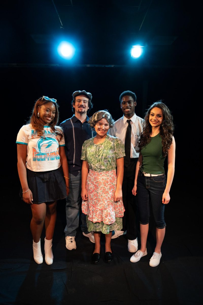 The main five characters posing together with joy (from left to right): Vanessa (Courtney Harris ‘26), Usnavi (Georgio Sardelis ‘27), Abuela Claudia (Grace Mueller ‘27), Benny (Kamdi Aghazu ‘28), and Ninac (Elsa Harlor ‘27)

olgchs

